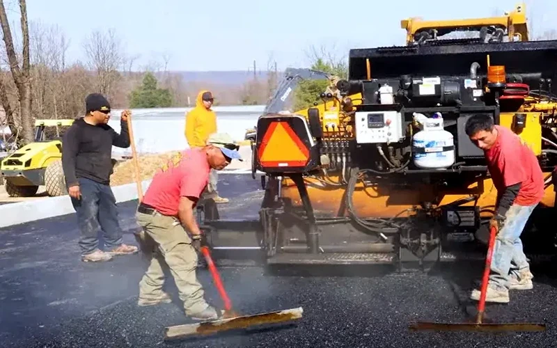 vp-paving-crew-raking-out-steaming-hot-350-degree-asphalt-behind-our-leeboy-1000-track-paver-machine